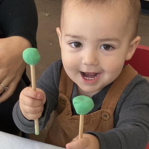 Vernon County Birth to 3 ARPA Grant Photo 9: Toddler holding sticks with Play-Doh on ends