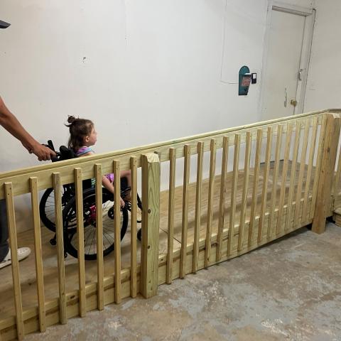 Child in wheelchair using the ramp into a home