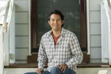 Smiling younger adult sitting on steps