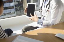 Doctor showing tablet to patient