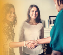 Two adults shaking hands as a third adult looks on