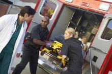 Two EMTs and a doctor unloading a patient from ambulance.