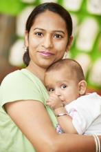 A person holding a baby sucking its thumb