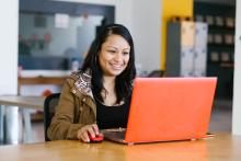 Person sitting at a table working on a laptop