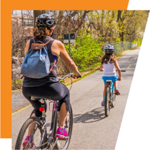 Adult and child biking on a bike trail