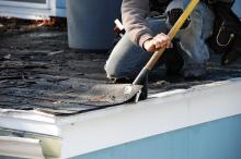 Person removing shingles from a roof