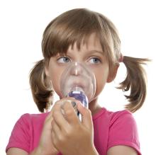 Young child with an inhaler and spacer