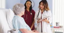 Medical professionals talking with a hospital patient.