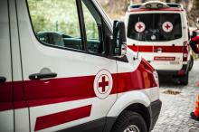 Two ambulances with red cross emblem on the passenger doors.