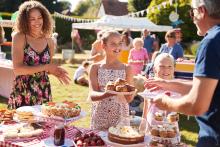 A cake stall with adults and children.