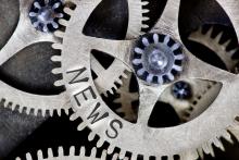 Interlocking gears with the word News imprinted