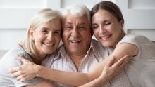 One adult and two older adults hugging