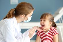 Doctor checking a child's throat