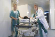 Doctors pushing a patient down a hospital hallway on a gurney