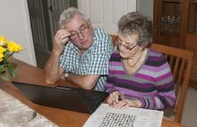 A couple playing a crossword puzzle at home.