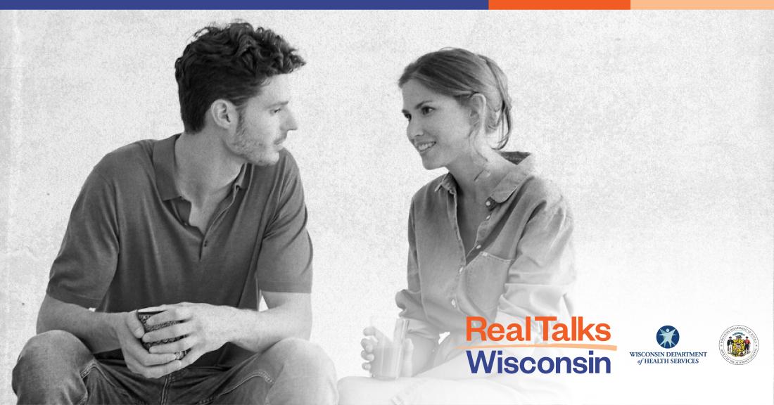 Two adults talking on a bench