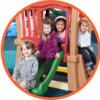 Four smiling children posing on a playground.